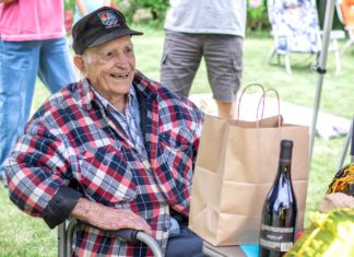 Tigard WWII Veteran Turns 100 Paul Herberholz, relaxing under a canopy tent awaits the many visitors while receiving many gifts and cards.