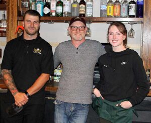 Ken Reigle (center) is proud of his staff at Infinity Golf that includes bartender Kyle Kirby and bartender/server Kayda Lacy.