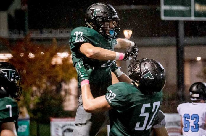 Junior Reese Hare (52) lifts up Henry Masters (23) in celebration.