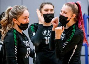 Isabel Williams (13), Emma Frye (10) and Alyssa Thoren (5) of Tigard volleyball celebrate after scoring on St. Mary’s Academy in their final season game.