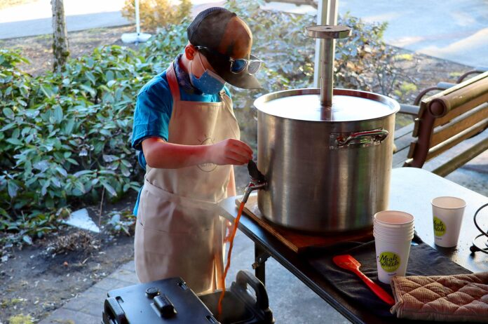 Cooper pouring coffee from Nossa Familia’s giant, custom welded French Press at a Feb.12 Cooper’s Coffee pop-up outside of Meals On Wheels People at the Tigard Senior Center.