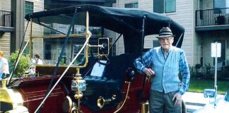 Lionel Domreis at age 99 poses with a beautiful automobile at a Car Show.