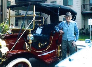 Lionel Domreis at age 99 poses with a beautiful automobile at a Car Show.
