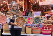 Haoua Cheick displaying a few of the woven basket designs available for purchase at the Bull Mountain Farmers Market each weekend.