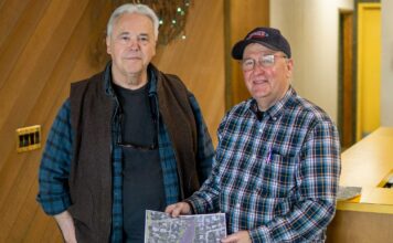 Tigard Old-Fashioned Fourth of July Celebration on for 2022 Ron Royse (left) and John Chamberlain hold an aerial photo showing Chamberlain Lake