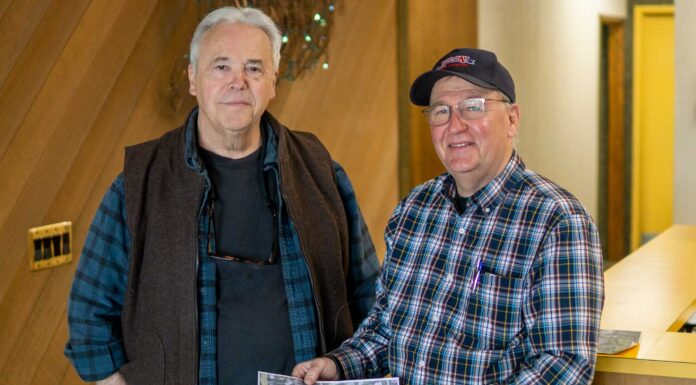 Tigard Old-Fashioned Fourth of July Celebration on for 2022 Ron Royse (left) and John Chamberlain hold an aerial photo showing Chamberlain Lake