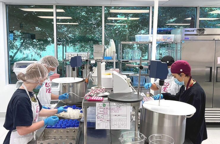 Members of the milk bank’s processing team dispense donor milk into bottles as part of the pasteurization process.