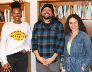The bookshelves in the house’s Tulip Room include books written by previous resident authors as well as artifacts belonging to Carolyn Moore, which are enjoyed by (from left) Sadia Hassan, Justin Rigamonti and Patrycja Humienik. 