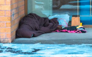 A homeless camper sleeps in front of the Tigard Post Office during the February 2023 winter storm.