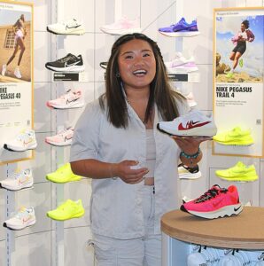 Kaytlin Lam holds a popular Nike shoe while standing in the women’s shoe department at the new Bridgeport Village store. 