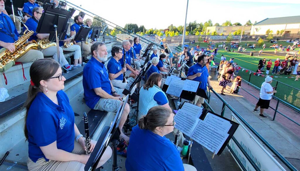 The Tualatin Valley Community Band performs overlooking the crowd at the 2022 Tigard Old-Fashioned Fourth of July Celebration.