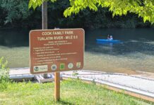 Council ‘triages’ Tigard parks’ looming shortfall Sign for the Cook Family Park boat launch on the Tualatin River with a kayaker in the background.