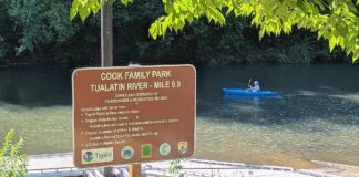 Council ‘triages’ Tigard parks’ looming shortfall Sign for the Cook Family Park boat launch on the Tualatin River with a kayaker in the background.