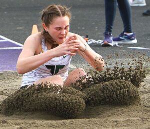 Tigard High School track athlete Sloan Brunscheon landing in the sand pit during a long jump competition at the Sunset Team Challenge.