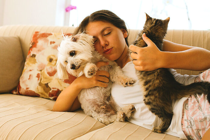 pet-talk-woman-on-couch-with-pets Woman on couch with pets