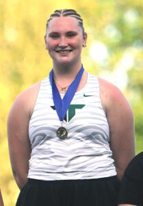 Tigard senior Marissa Johnson celebrates with her medal for winning the discus event at the Three Rivers League.
