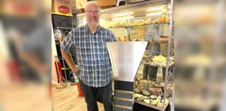 Tigard store channels gold-mining magic Dan Rouse, owner of Prospector's Treasure Trove, stands with a sluice box in front of a display case showing gold-mining artifacts in his store.