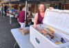 Food Bank Forges On, Even Without Permanent Location Tigard Community Food Project founder Amy Fierderowicz helps man the meat station while volunteers hand out groceries to people on Oct. 6.