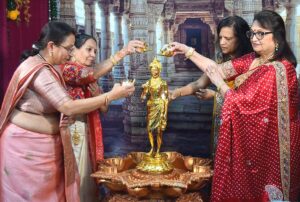 Women standing around a statue at a Diwali celebration.